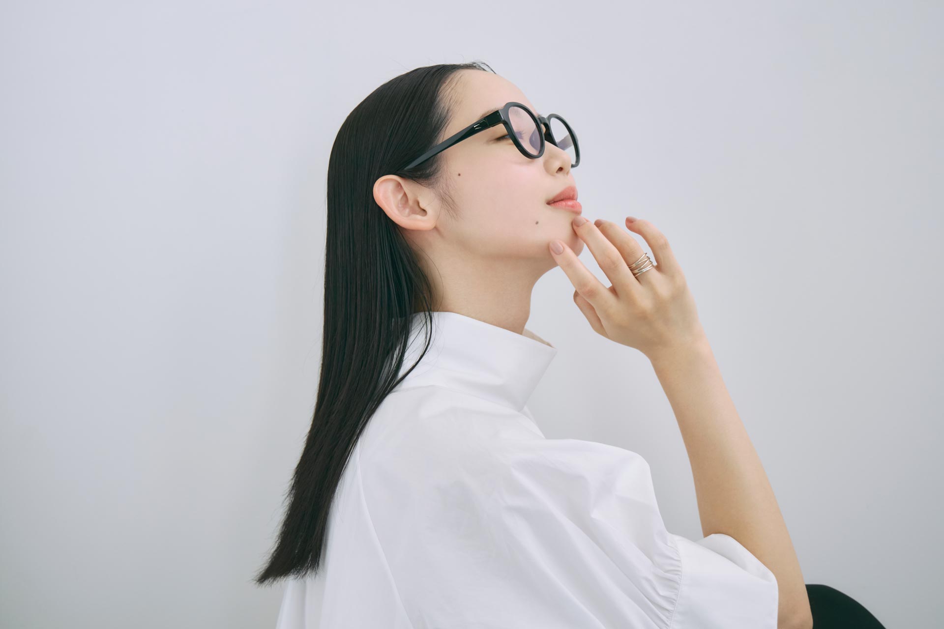 MEGLASSを着用した女性の横顔。ミニマルな空間で、日常に馴染むリカバリーアイウェアの着用イメージ